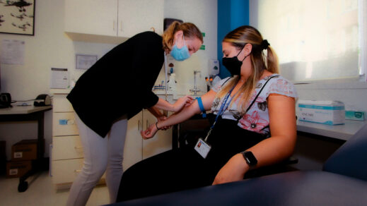 Patient receiving blood products from New York Blood Center Enterprises phlebotomist