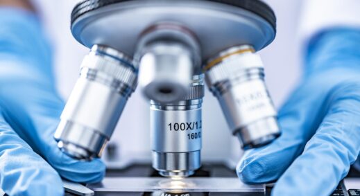 New York Blood Center Enterprises researcher using microscope to study a blood sample on a petri dish