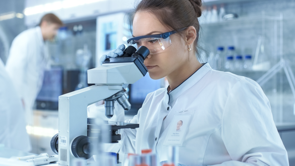 Researcher looking through microscope in laboratory