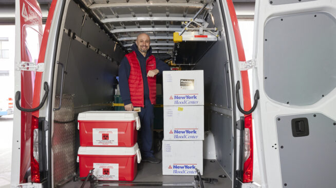 NYBCe staff member loading blood products into van for transport.